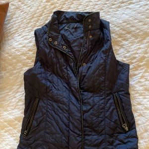Lightweight navy blue puffer vest with black feaux leather accents